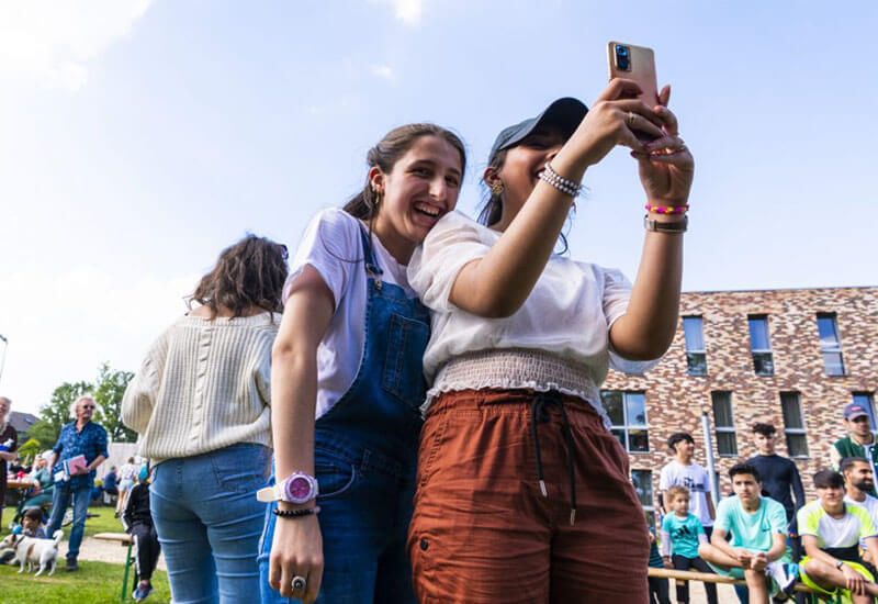 Twee tieners maken lachend een selfie op het Vergezichtenfestival.