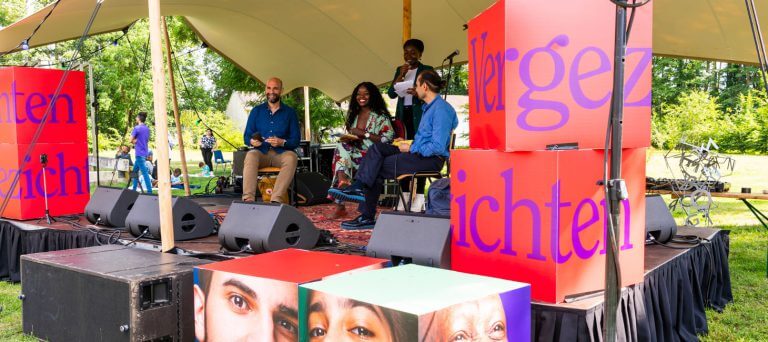Vier schrijvers dragen voor op het podium van het Vergezichtenfestival