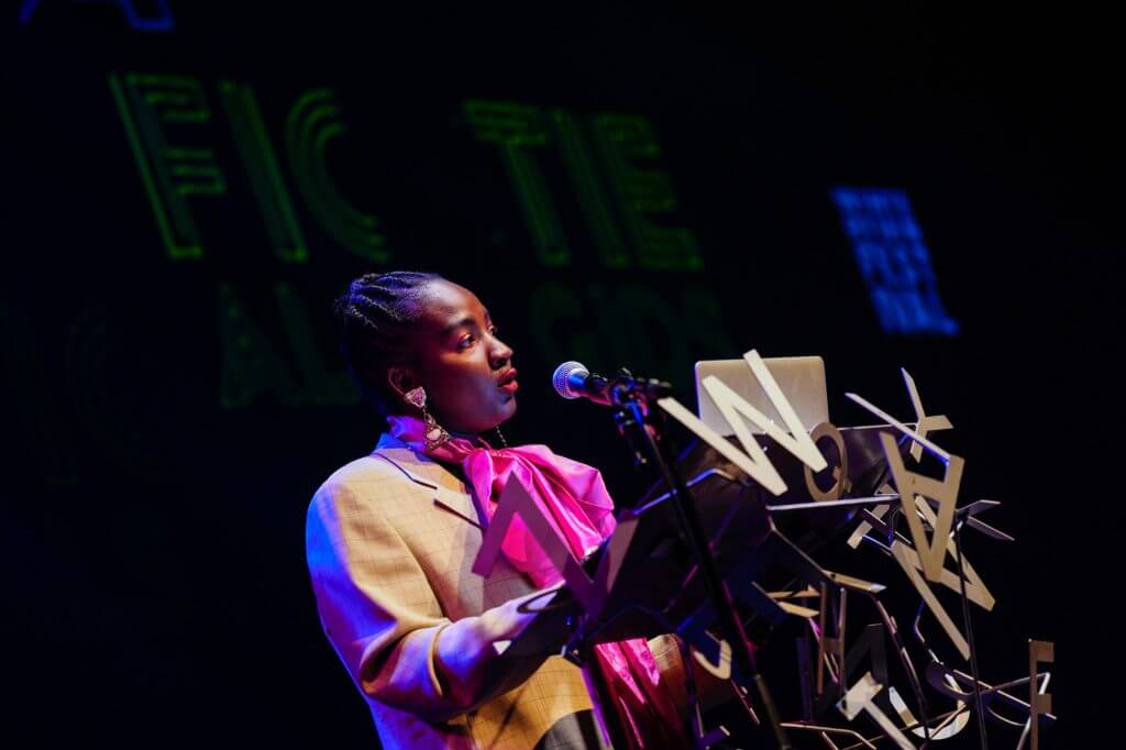 Munganyende Hélène Christelle draagt voor achter een katheder op het Wintertuinfestival.