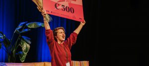 Ceren Uzuner wint de Afstudeerprijs en houdt juichend de cheque omhoog